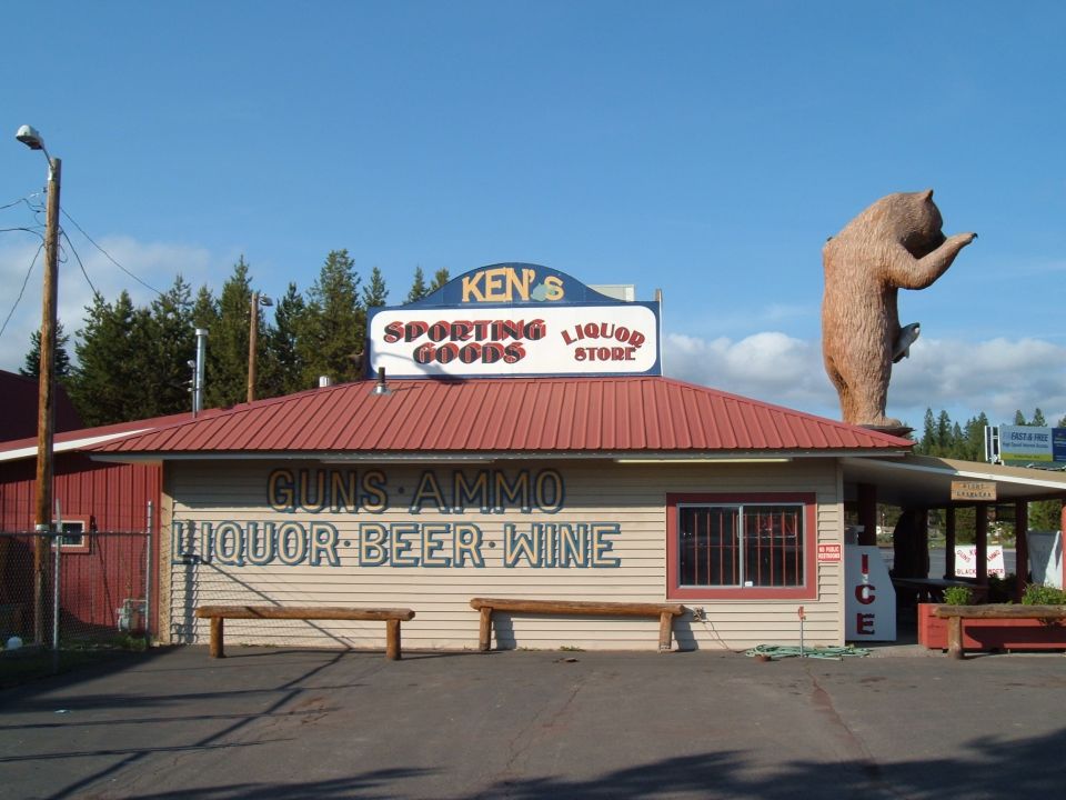 Store with large bear statue and signs for sporting goods, liquor, beer, and wine
