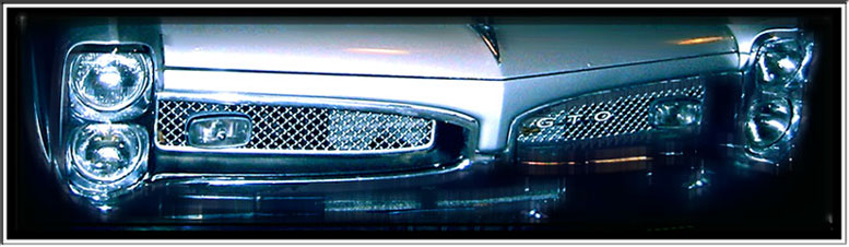 Close-up of Pontiac GTO front grille with stacked quad headlights and GTO badge