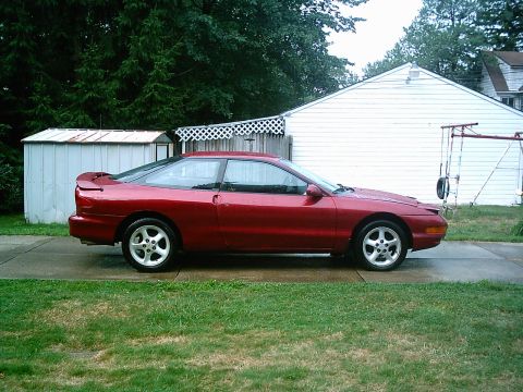 1993 Ford Probe - Side view of a red 1993 Ford Probe coupe parked in a residential driveway.