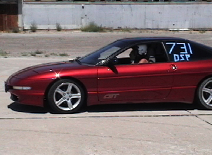 Side view of a red 1996 Ford Probe with racing numbers 731 DSP on the rear window
