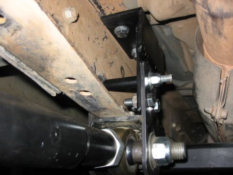1995 Ford Bronco - Close-up of aftermarket suspension components bolted to a vehicle's frame.