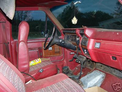 1986 Ford F-150 - Interior of a red pickup truck, likely from the early 1980s, showing the dashboard and seats.