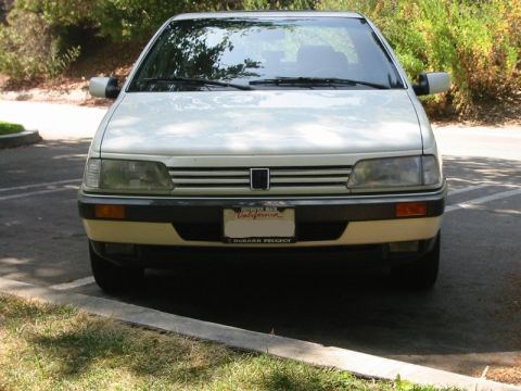1989 Peugeot 405 - Frontal view of a white 1989 Peugeot 405 sedan, showing its distinctive grille and headlights.