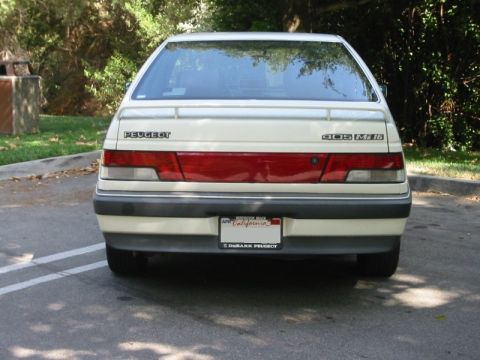 1989 Peugeot 405 - Rear view of a white Peugeot 405 Mi16 sedan, a red taillight bar and a California license plate.