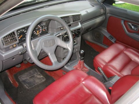1989 Peugeot 405 - The interior of a 1989 Peugeot 405 features red leather seats and a grey dashboard with clear instrumentation.