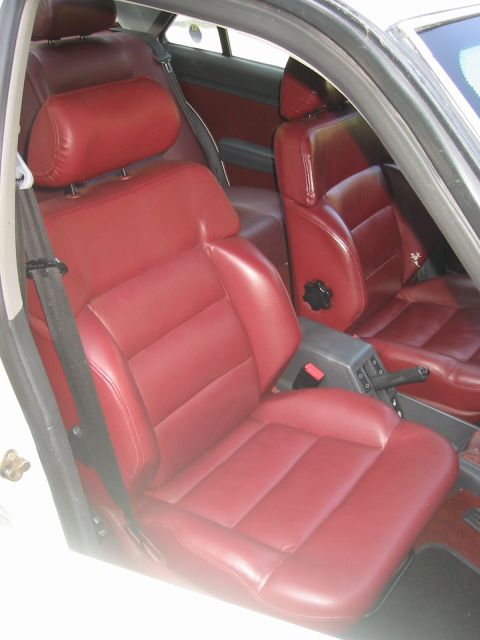 1989 Peugeot 405 - The interior of a car with red leather seats is shown from the passenger side.