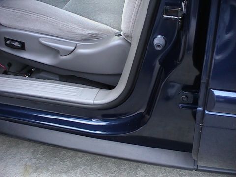 2000 Ford Taurus - Interior view of a car door frame and seat, showing gray upholstery and dark blue exterior paint.