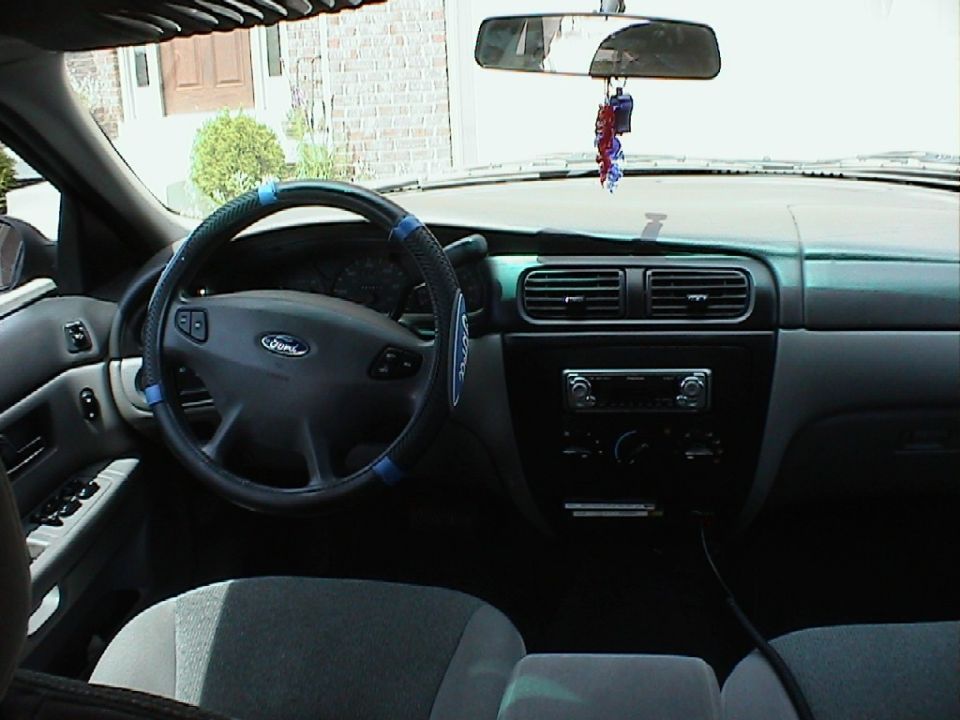 Interior view of a 2000 Ford Taurus, showing the steering wheel, dashboard, and center console