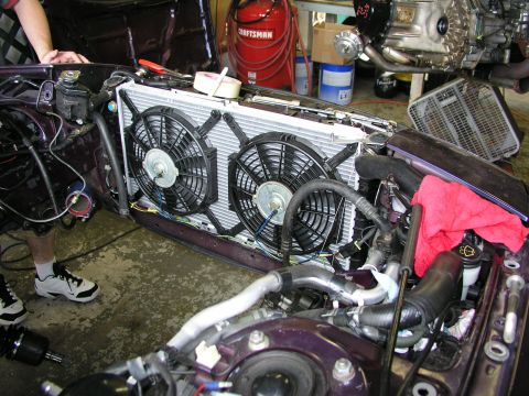 1996 Ford Probe - Close-up view of a car's engine bay, focusing on the radiator and cooling fans during a repair or upgrade.