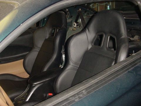 1995 Ford Mustang - The interior of a car features two bucket seats and a center console, with visible Supermotors.net branding.