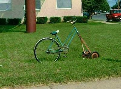 1972 Ford Ranchero - A bicycle has been modified with a lawnmower attachment and is parked on a grassy lawn.