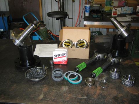 1999 Ford F-250 - Automotive parts including Spicer hub assemblies and bearings are displayed on a workbench.