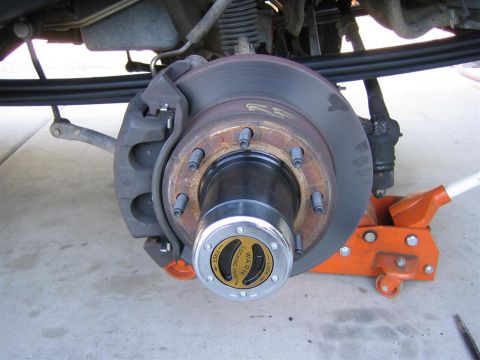1999 Ford F-250 - Close-up of a vehicle's front wheel hub assembly, showing the brake components and a manual locking hub.