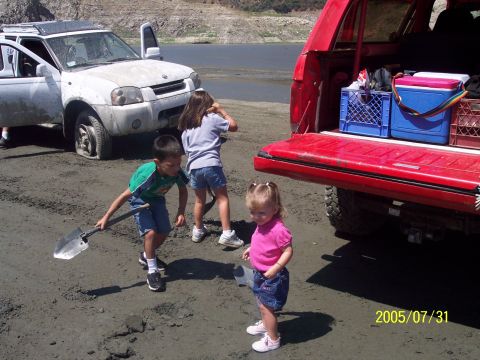 1985 Ford Bronco - Children and vehicles by a lake on a sunny day.