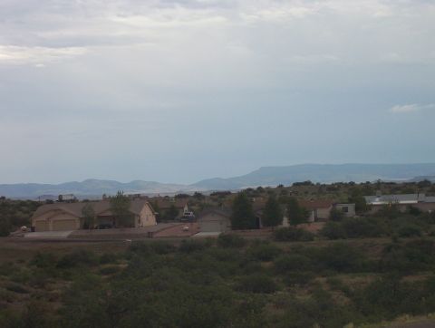 1995 Ford Bronco - A wide view of a residential area with houses, trees, and distant mountains under an overcast sky.