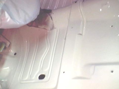 1966 Ford Fairlane - The interior floor of a vehicle, recently painted white, with visible structural details and drainage features.
