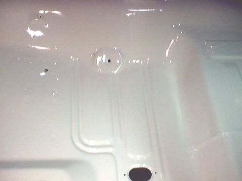 1966 Ford Fairlane - The underside of a vehicle's floor pan is visible, showing a white painted surface with structural reinforcements.