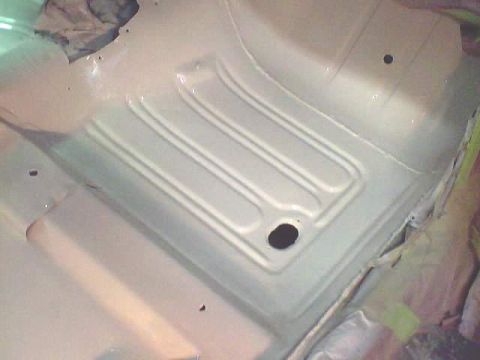 1966 Ford Fairlane - Close-up of a freshly painted car floor pan, showing ribbed details and a drain hole.