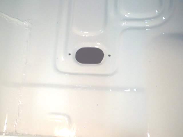 White painted floor pan with a grommet hole