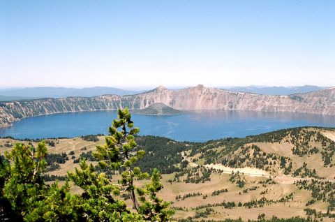 1979 Ford Bronco - A vast blue lake is surrounded by cliffs and rolling hills dotted with trees.