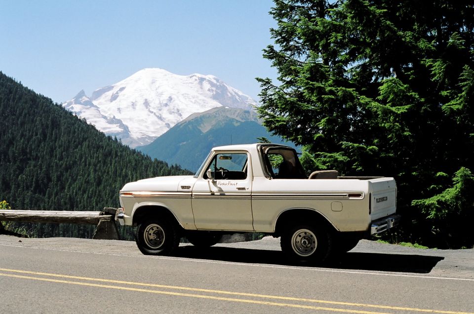 White 1978 Ford Bronco parked on a mountain road, side view