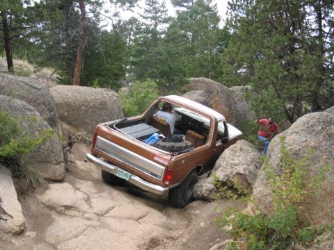 1981 Ford Bronco - Ford Bronco attempting to traverse a difficult rocky obstacle on an off-road trail.