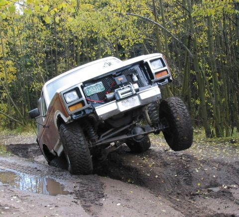 1981 Ford Bronco - This modified Ford Bronco navigates a challenging muddy off-road course with one wheel lifted.