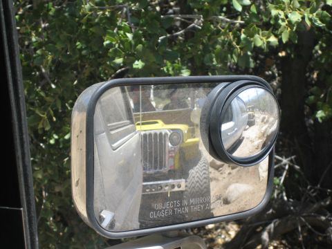 1990 Ford Bronco - side mirror reflects a yellow flat-fender open-top off-road vehicle behind, with the etched text 'objects in mirror are closer than they ap…