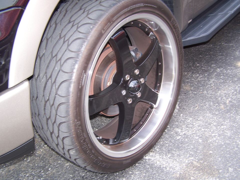 Close-up of black five-spoke wheel with polished lip and BFGoodrich low-profile tire on a truck