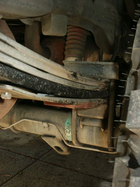 1996 Ford Bronco - Close-up view of the rear suspension system on a 1996 Ford Bronco, highlighting the leaf springs and shock absorber.