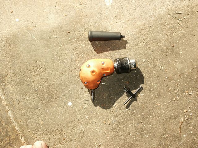 Right angle drill with chuck and chuck key on concrete