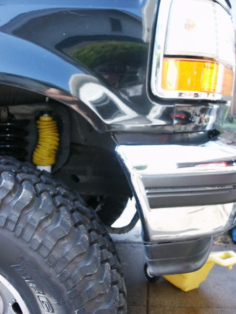 1996 Ford Bronco - Close-up of the front corner of a 1996 Ford Bronco, showing the tire and bumper.