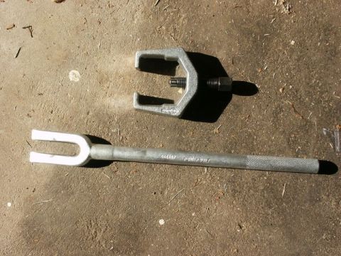 1996 Ford Bronco - A ball joint separator tool set is shown on a concrete surface.