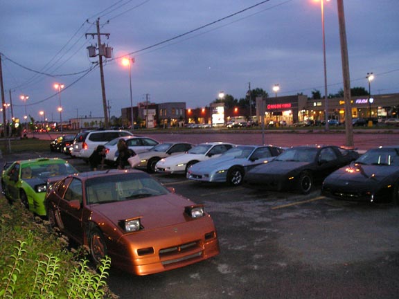 Orange 1984 Pontiac Fiero with pop-up headlights parked in a lot