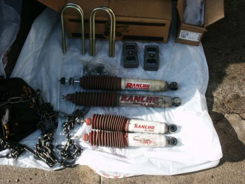 1996 Ford Bronco - Rancho suspension parts, including shocks and U-bolts, are displayed on a plastic sheet.
