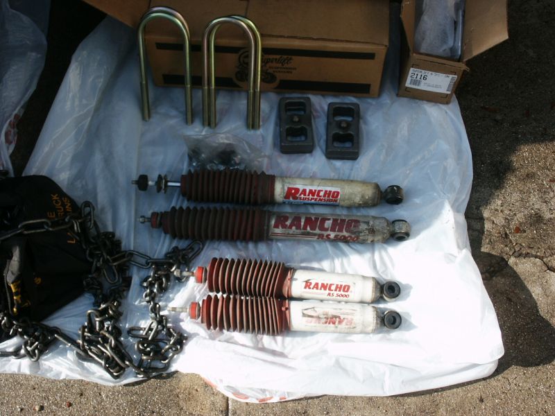 Rancho RS 5000 shocks, U-bolts, and lift blocks laid out on a plastic sheet