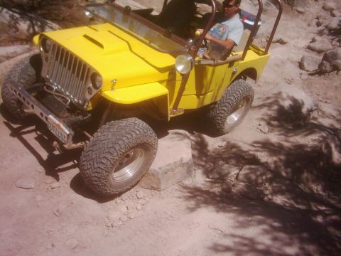 1978 Ford Bronco - A yellow off-road vehicle navigates a rocky trail.