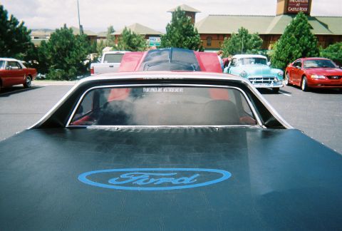 1972 Ford Ranchero - A 1972 Ford Ranchero is seen from the rear, a prominent Ford logo on its tonneau cover and a sticker on the back window.