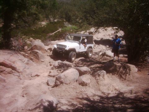1978 Ford Bronco - Jeep Wrangler tackling a challenging rocky path during an off-road excursion.