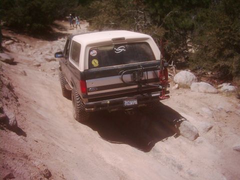 1978 Ford Bronco - Ford Bronco navigating a challenging off-road trail with rocky terrain.