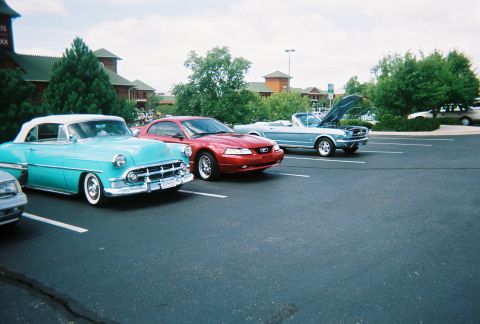 1972 Ford Ranchero - A turquoise 1954 Chevrolet Bel Air convertible is parked in a lot with two Ford Mustangs.