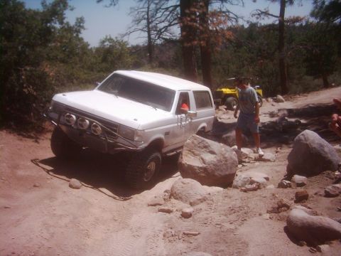 1978 Ford Bronco - A white Ford Bronco tackles a challenging rocky terrain on an off-road adventure.
