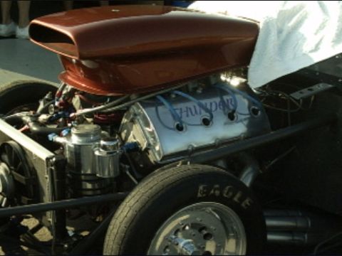 1990 Ford LTD Crown Victoria - Close-up of a drag racing engine a prominent scoop and 'Thunder' inscribed on the valve covers.