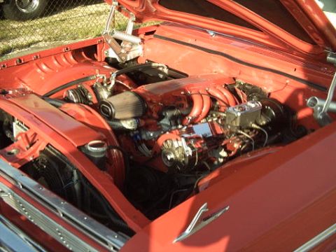 1990 Ford LTD Crown Victoria - Engine bay of a red car, showing the motor and various components. Supermotors.net logo is present.