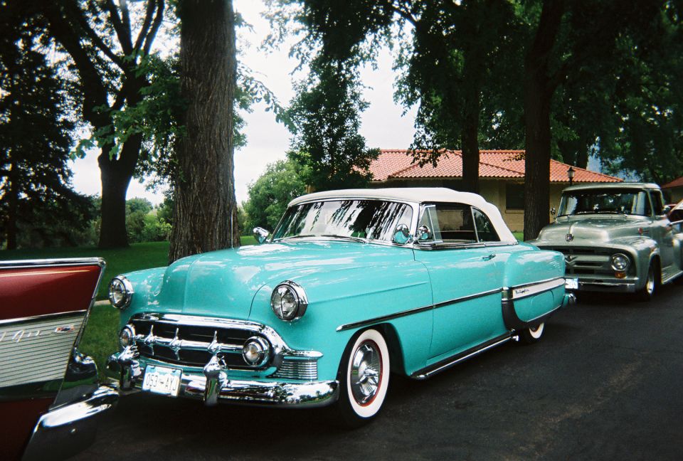 Turquoise 1950s Chevrolet Bel Air convertible with white top and whitewall tires at a show