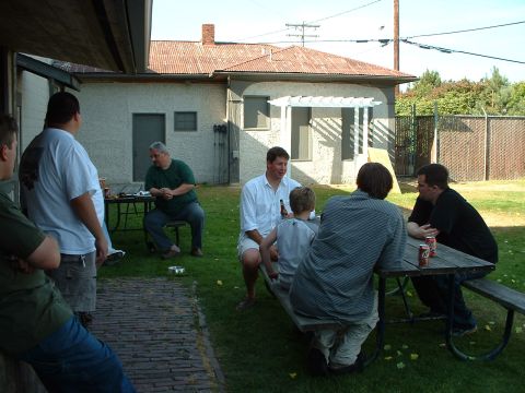 1999 Ford Crown Victoria - A group of men enjoy a casual gathering in a backyard on a sunny day.