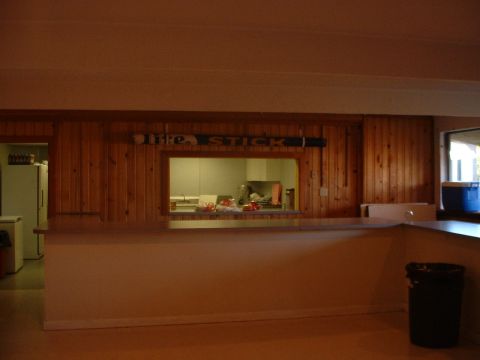 1999 Ford Crown Victoria - An interior view of a room with wood-paneled walls and a pass-through window revealing a kitchen area. A sign reading "Life Stick" is visib…