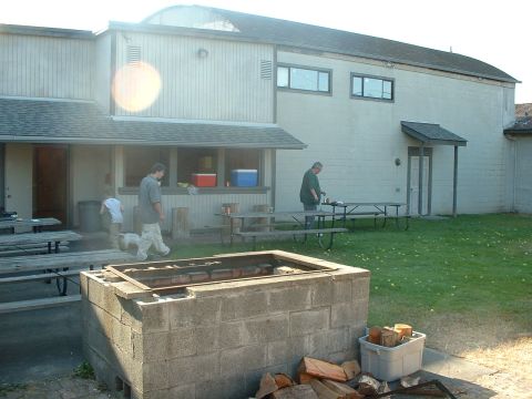 1999 Ford Crown Victoria - An outdoor gathering takes place with picnic tables and a large cinder block grill in the foreground.