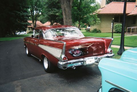 1972 Ford Ranchero - A classic red Chevrolet is parked on a paved surface, with a light blue vehicle partially visible in the foreground.