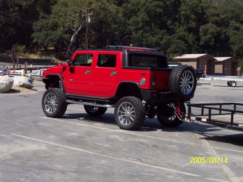 1985 Ford Bronco - Hummer H2 SUT parked outdoors, showing its rear profile and custom modifications.